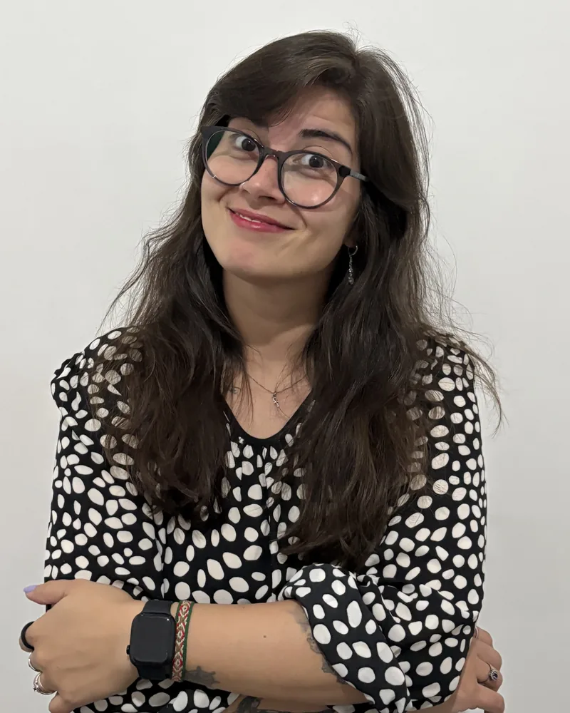 Paula Cremasco, criadora do Little Hands Focus, sorrindo de braços cruzados